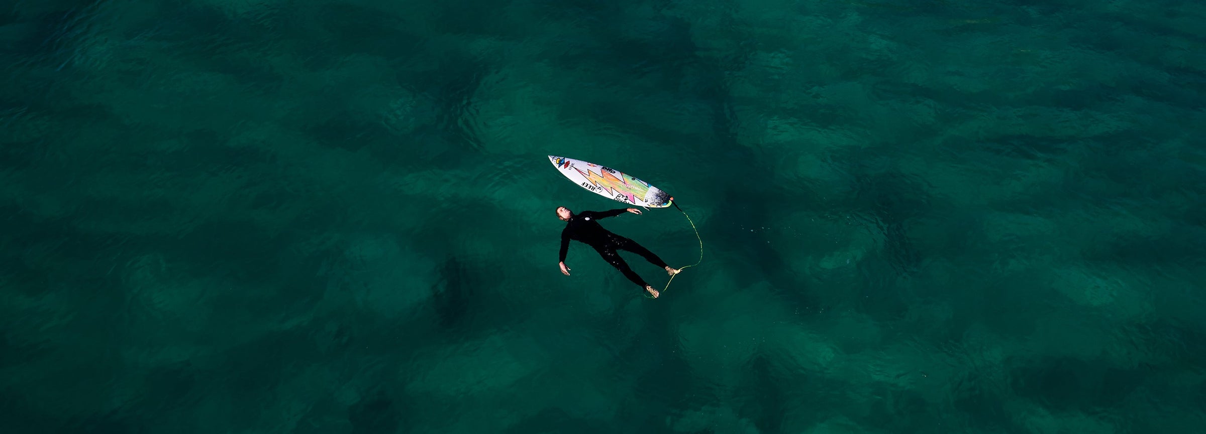 Man floating in ocean with surfboard