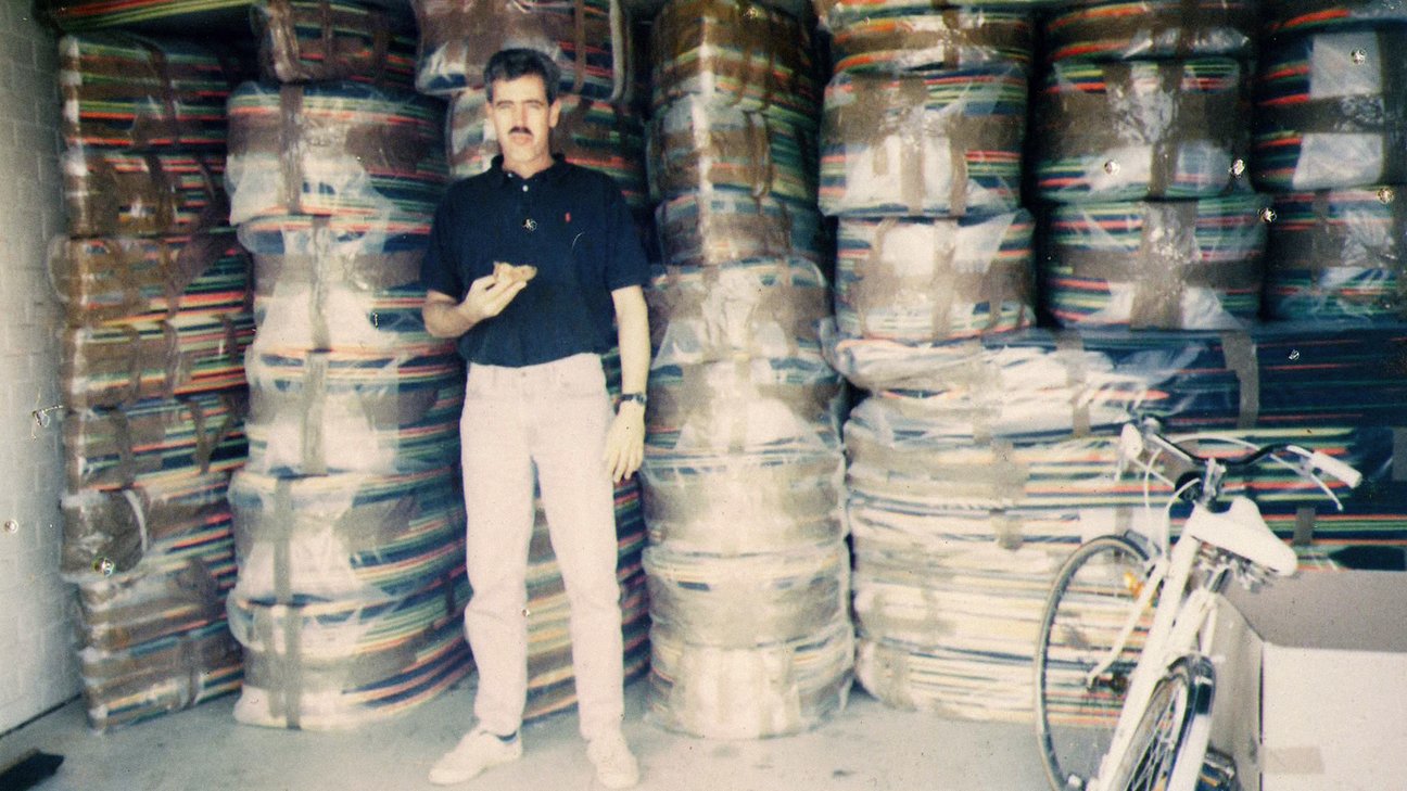 Older image of man standing in front of storage area