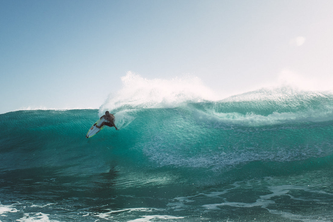 Man surfing into big turquoise wave