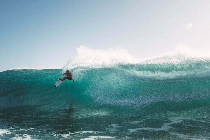 Man surfing into big turquoise wave