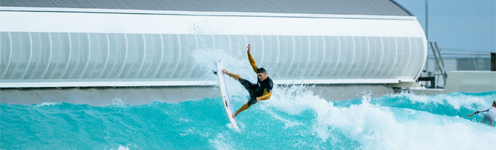 Man surfs in wave pool