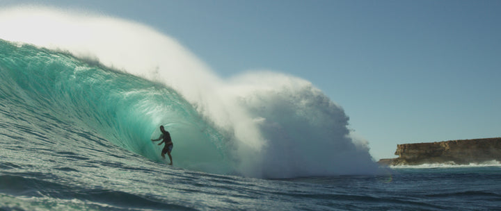 Person surfing in big barrel wave