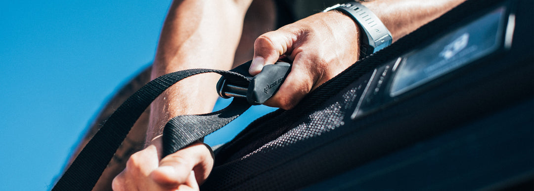 Man tightening straps on a board bag