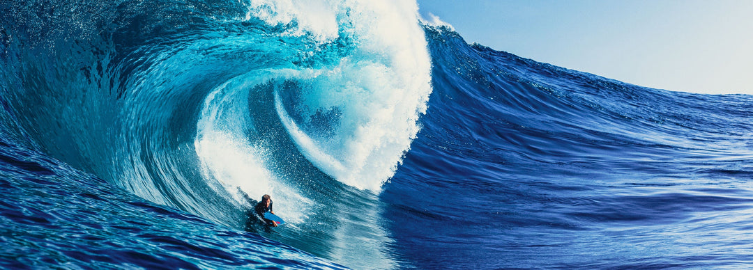 Man catching a big curling wave while body boarding