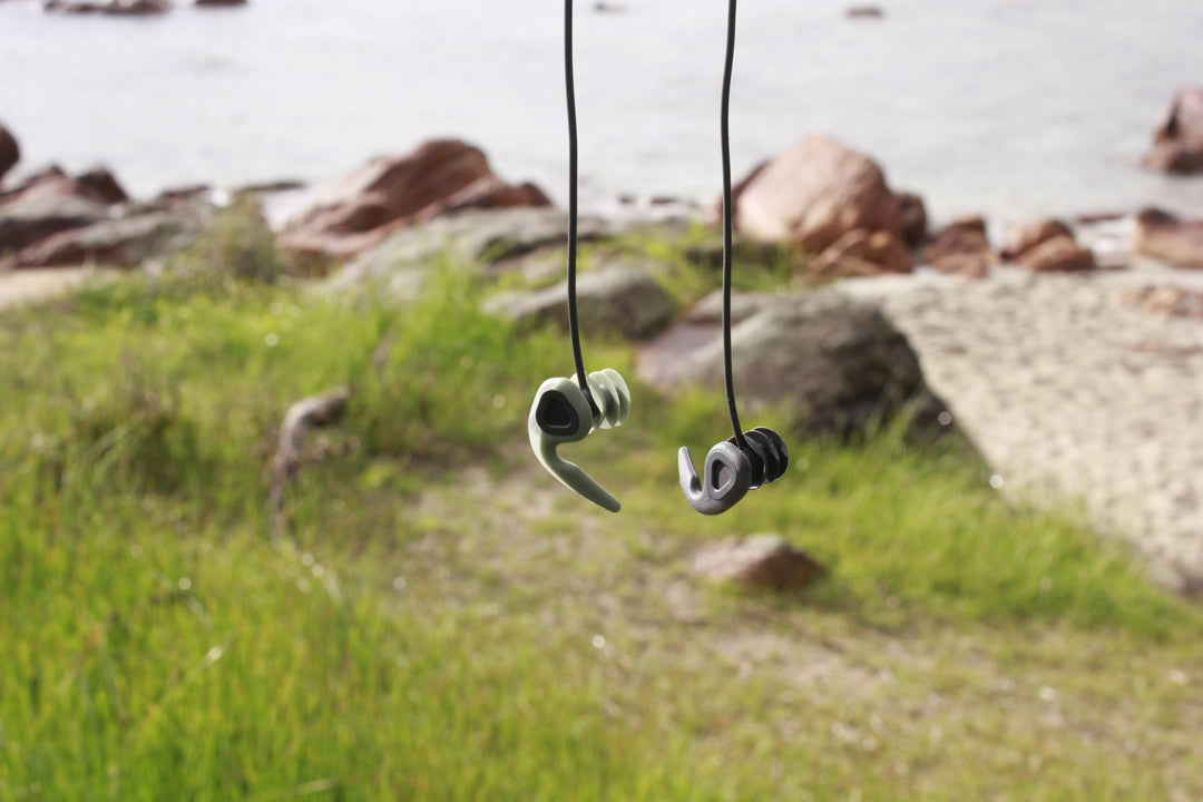 Smiling man putting surf ear plugs in