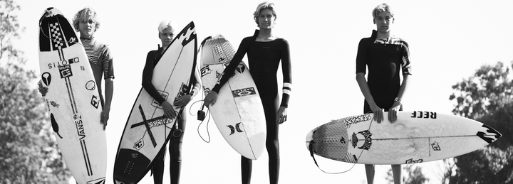 Black and White image of 4 boys with surfboards