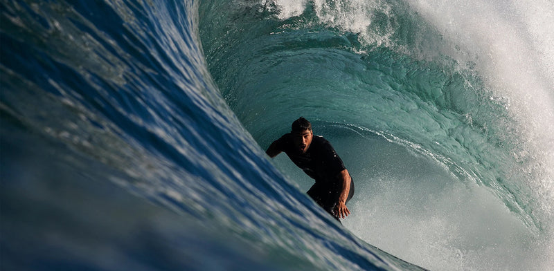 Orange sand beach meeting blue ocean with waves crashing on beach