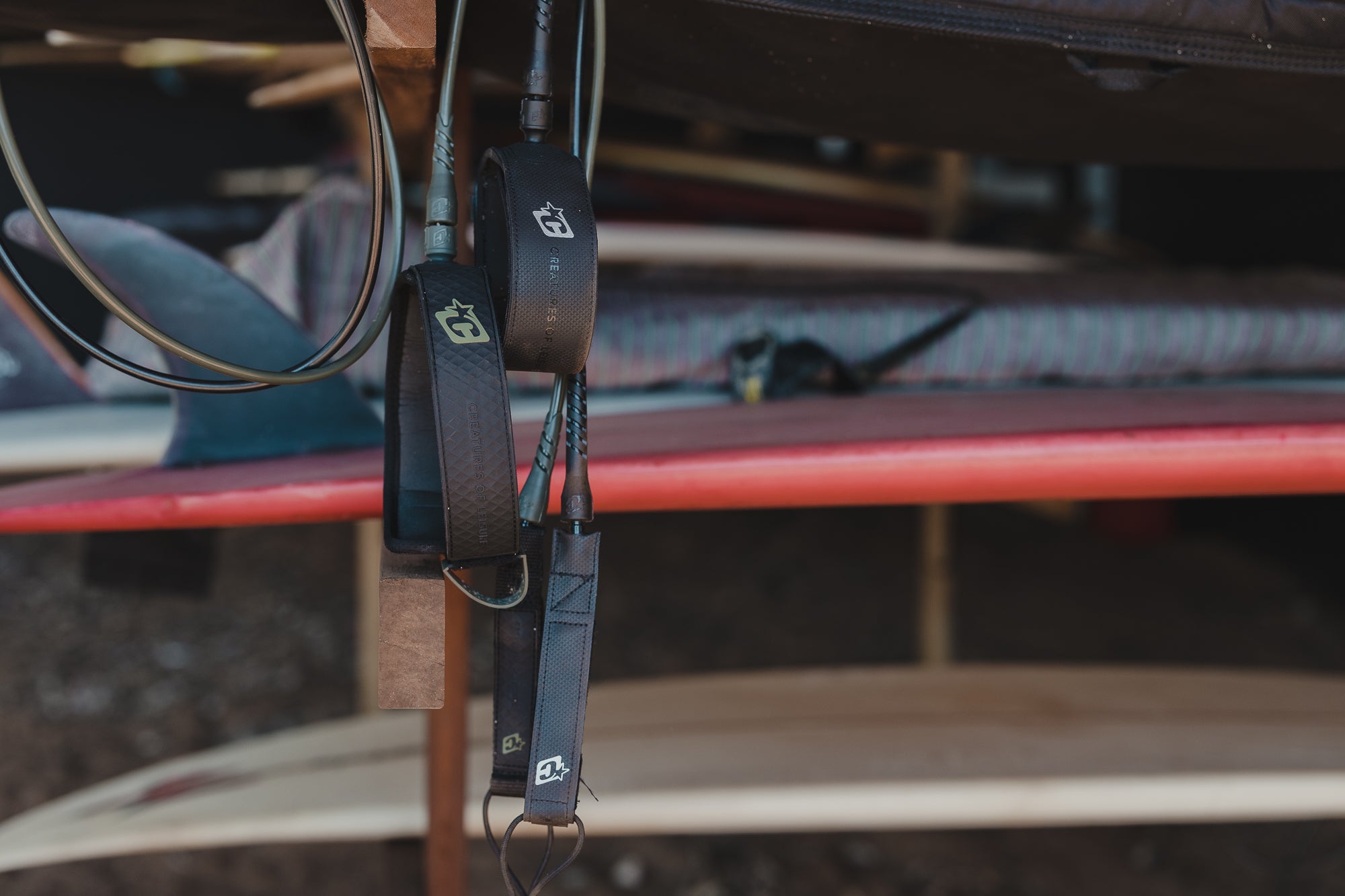 leashes hanging in garage with surfboard